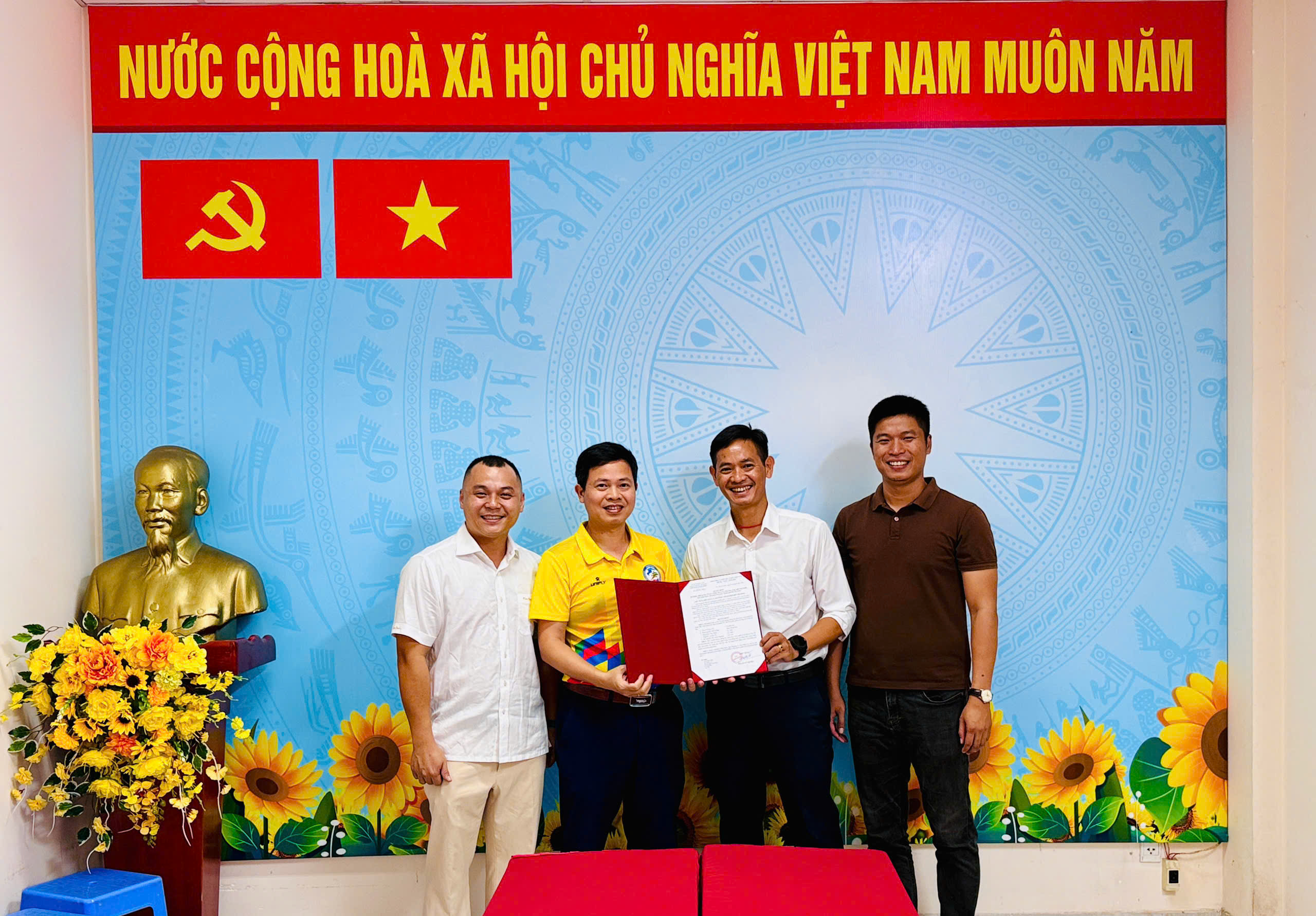Các thành viên Ban Truyền thông, Thông tin và Khoa học Công nghệ tại Hội nghị, với một hồ sơ màu đỏ được mở ở trung tâm ảnh.